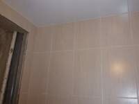 Стены в ванной выложены и смонтирован натяжной потолок