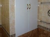 Двери из МДФ белого цвета закрывающие шкаф в ванной за которым скрыты все коммуникации.